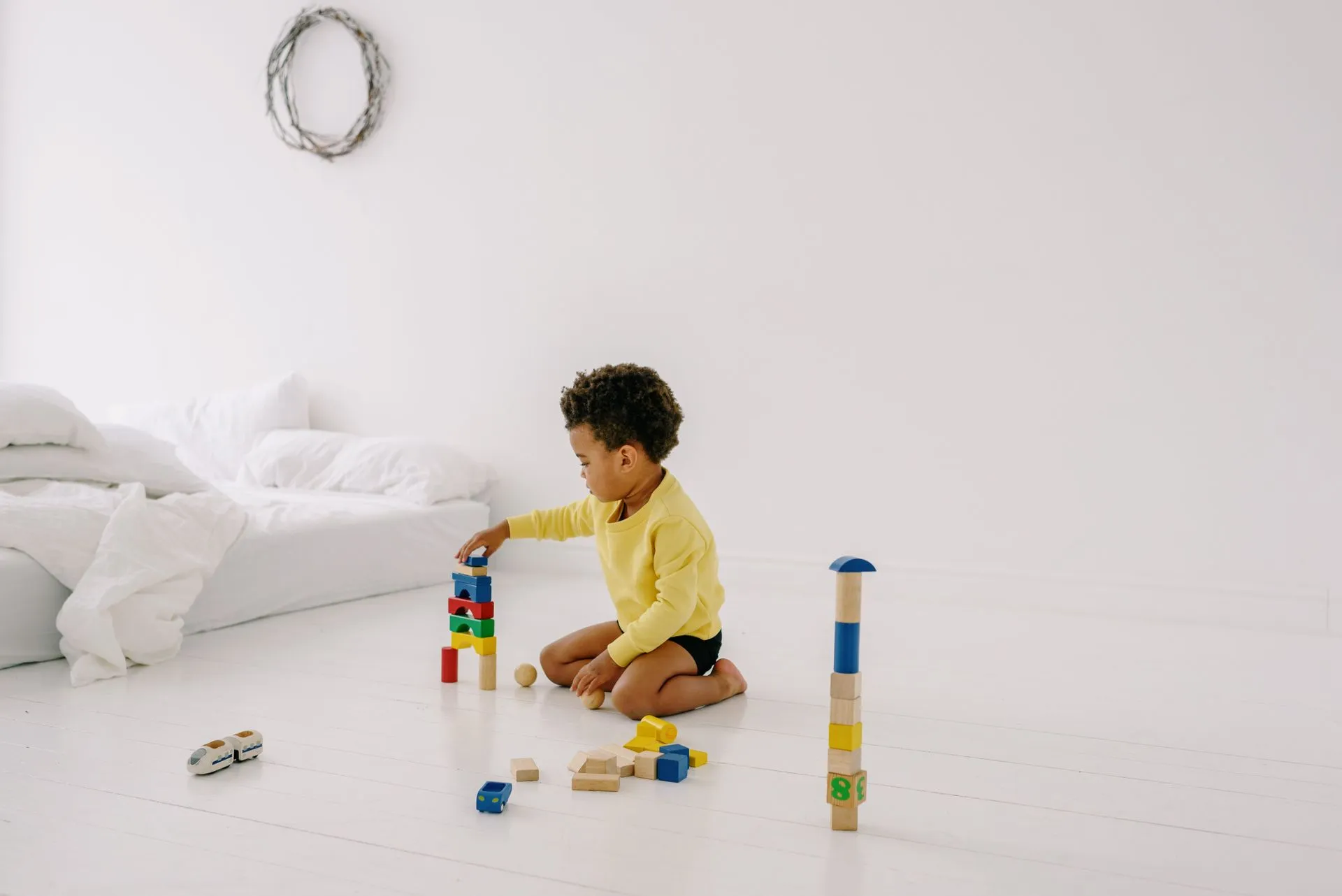 Young child building with wooden blocks on the floor at home